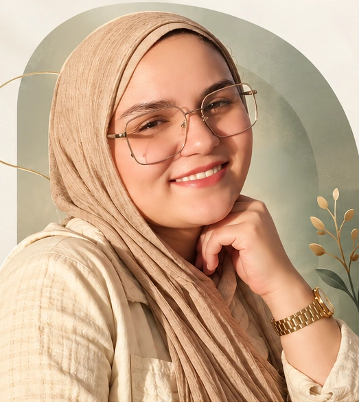 كريمان كارم بابتسامة هادئة، ترتدي حجابًا بيج ونظارة وساعة ذهبية